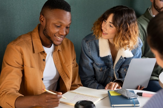 Foto gratuita amici che studiano da notebook e laptop durante la sessione di studio