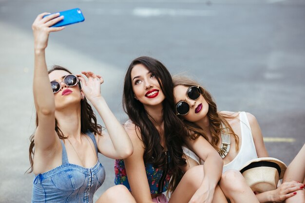 Friends taking a photo sitting on the asphalt