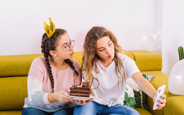 Friends taking a selfie with slice of cake