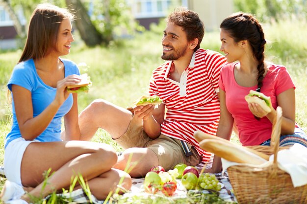 Friends talking and eating in the park