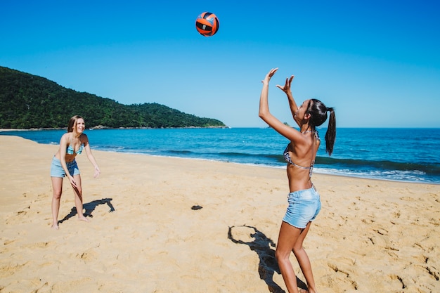 Friends throwing ball at the beach
