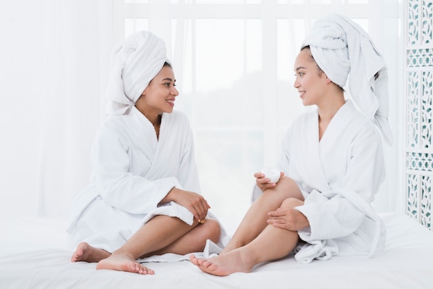 Friends using beauty cream in a spa