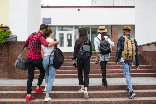 Friends walking up stairway to university