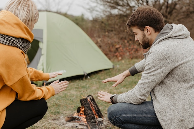 Friends warming up on campfire