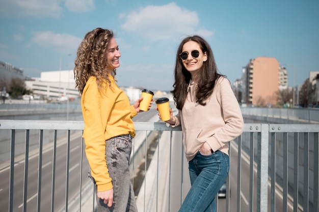 Friends wearing sunglasses holding cup of coffee