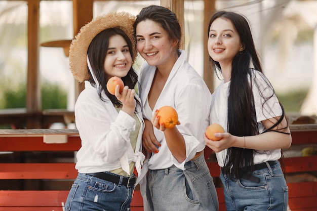 Amici con la frutta. ragazza con un cappello. donna in una maglietta bianca.