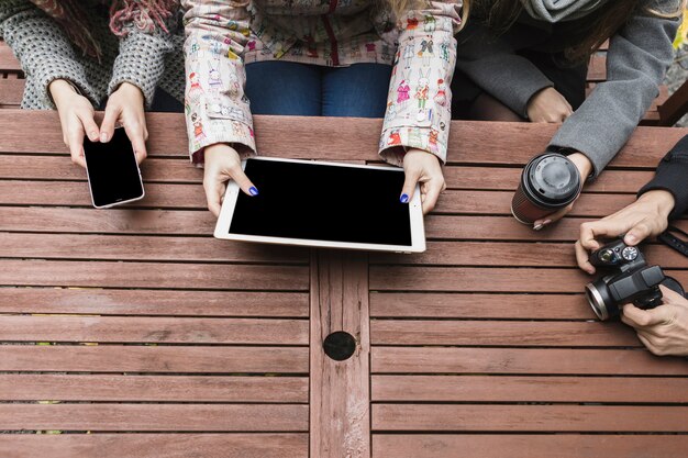 Friends with gadgets at table