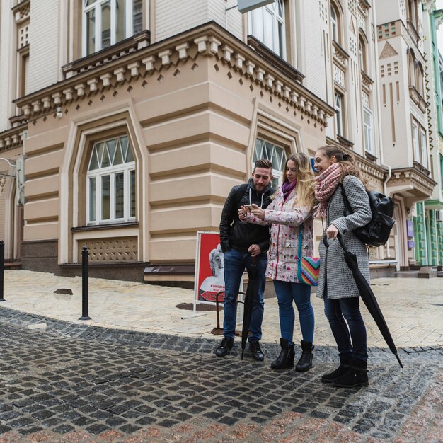 Friends with smartphone on street