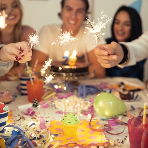 Amici con sparklers alla festa di compleanno