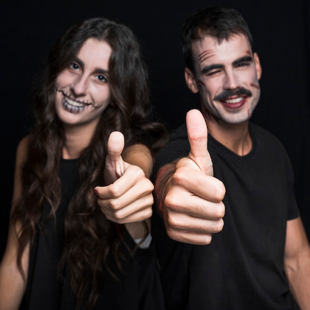 Friends with spooky makeup putting thumbs up