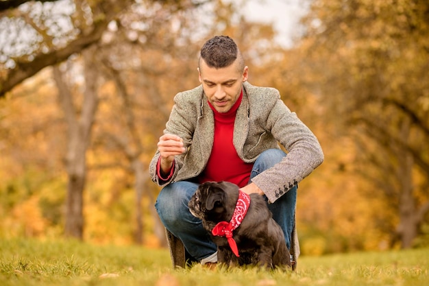 Friends. A young man with his pet in the autumn park