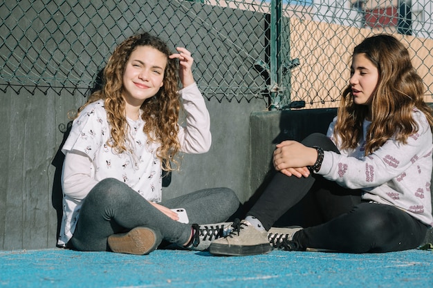 Friendship concept with girls sitting on sunny rooftop