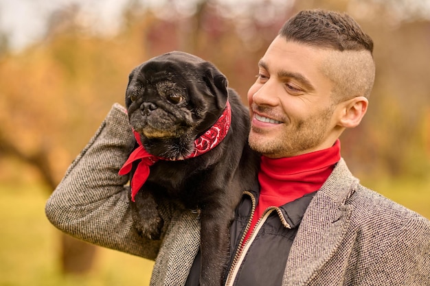 Foto gratuita amicizia. un uomo sorridente felice con il suo cane nel parco