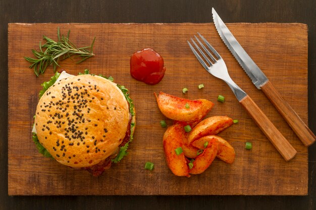 Fries and hamburger on wooden board