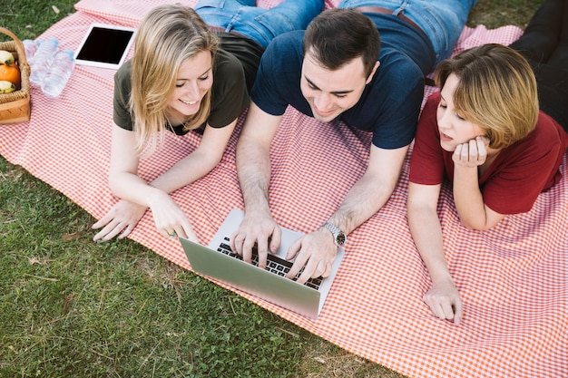 Бесплатное фото Сверху друзей, используя ноутбук на пикнике