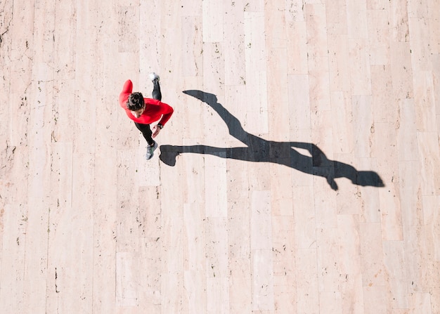 From above athlete running on pavement