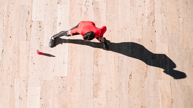 From above athlete stretching legs