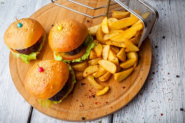 From above burger with french fries and frying basket in food board