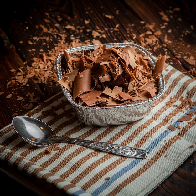 From above chocolate slices with spoon and rag in foil container