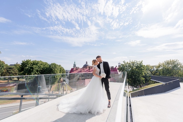 From a distance view of beautiful newlyweds hugging on the urban background