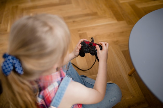 From above girl playing video game