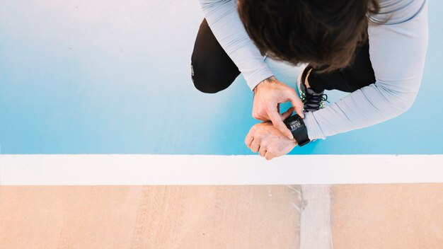 Free photo from above man checking smartwatch