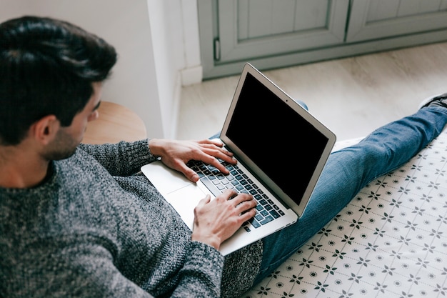 Free photo from above man using laptop on bed