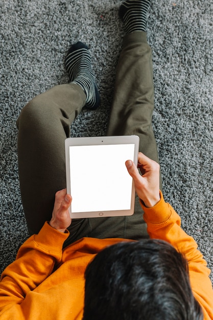 From above man with tablet on floor