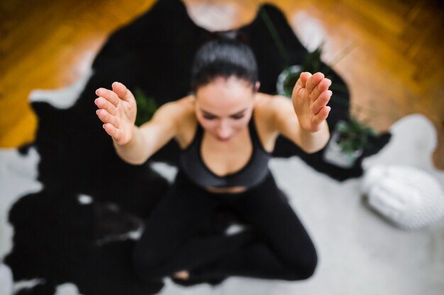 From above meditating woman with raised hands