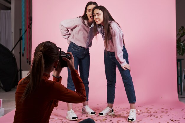 From below. Picture of two girls that photographed by female cameraman in the studio