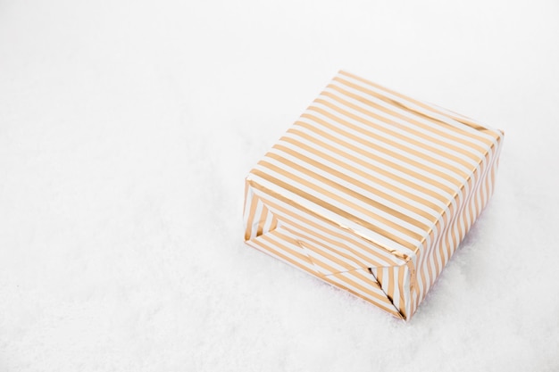 Сверху выстрел из ярких подарочных коробок, украшенных лентой, лежащей на белом снегу