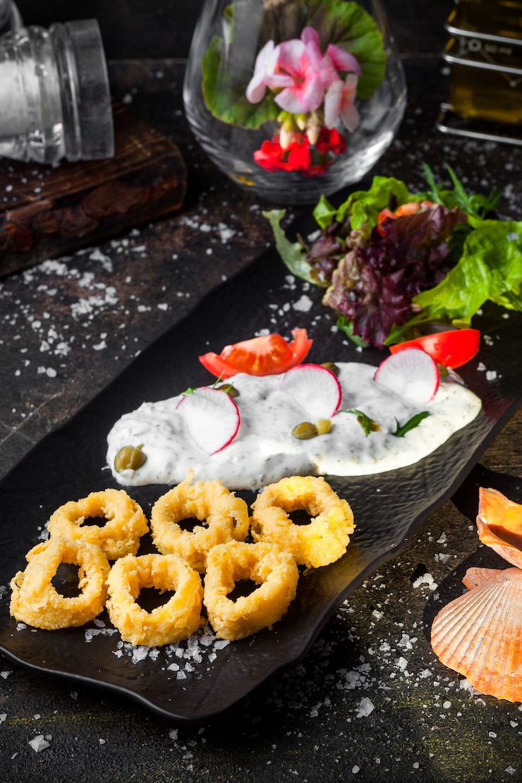 Free Photo from above squid rings in batter with fresh vegetable salad and sauce and flowers in tray