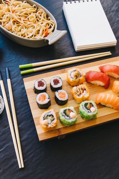 Free photo from above sushi near notebook and noodles