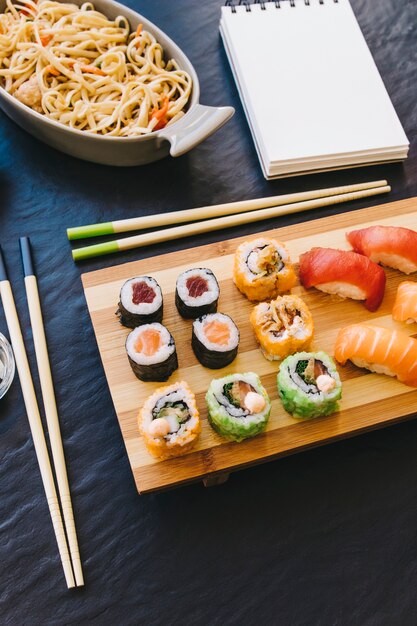 From above sushi near notebook and noodles