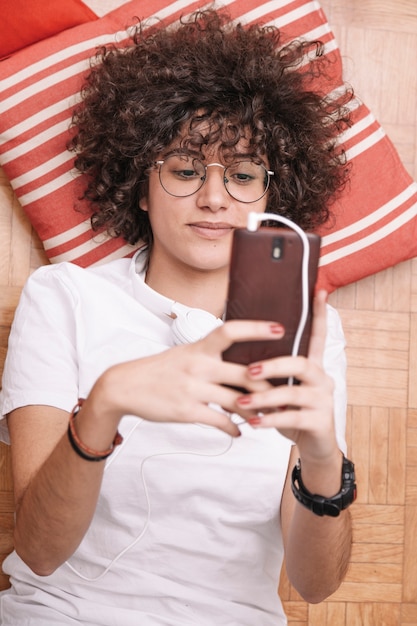 Free photo from above teenager browsing smartphone