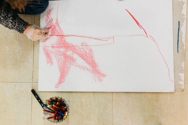 From above woman drawing on floor