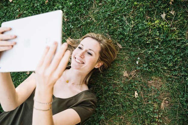 From above woman on grass using tablet