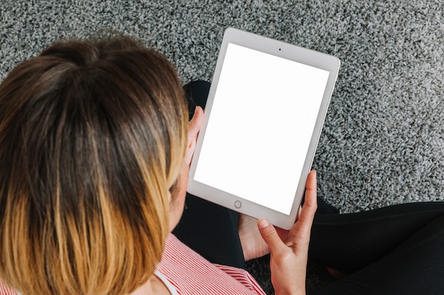 From above woman using tablet on floor