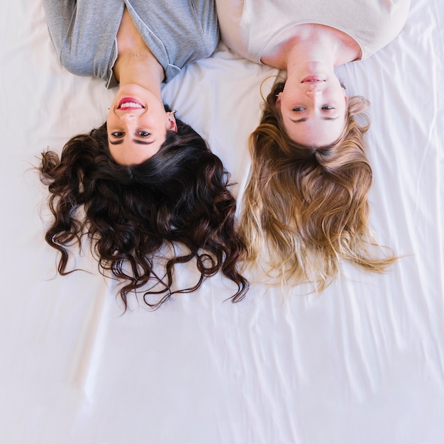 From above women lying on white sheet