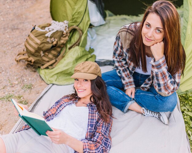 From above women reading near tent