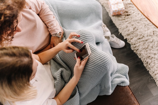 From above women using smartphone together