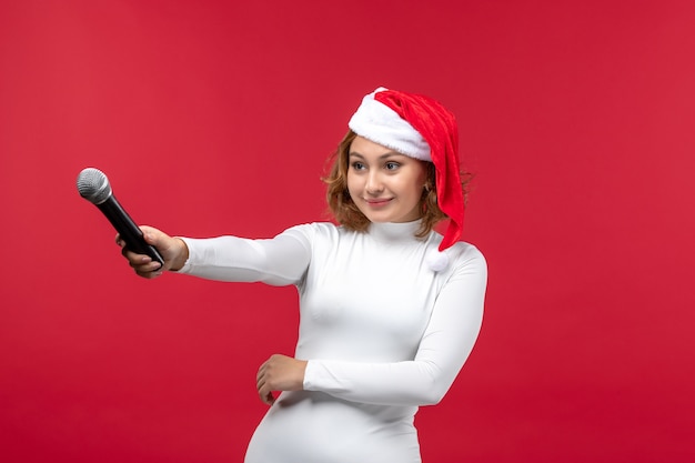 Free photo fron view of young female holding mic on red