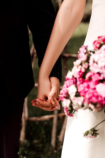 A front close up view pair loving man and woman holding each others hands during wedding