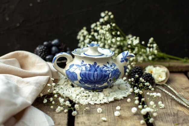 A front close up view white blue kettle on the white tissue on the wooden rustic floor