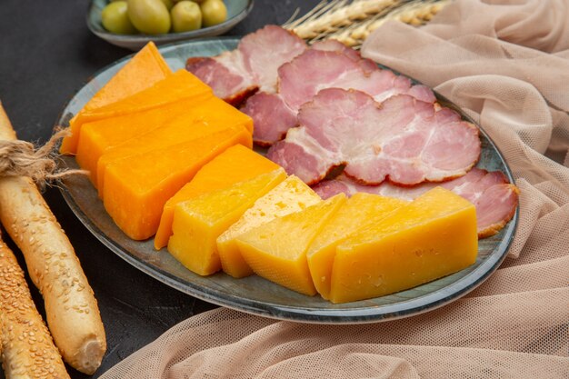 Front close view of best delicious snacks for wine on a towel on a dark table