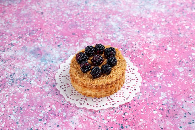 Front close view blackberry cake little fruity cake on light-pink background.