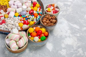 Free photo front close view candy composition different colored candies with marshmallow on white desk