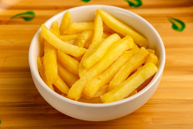 Front close view cooked french fries inside white plate on wooden desk potato food meal snack