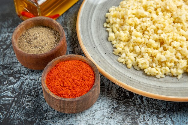 Front close view of cooked pearl barley with seasonings on light surface