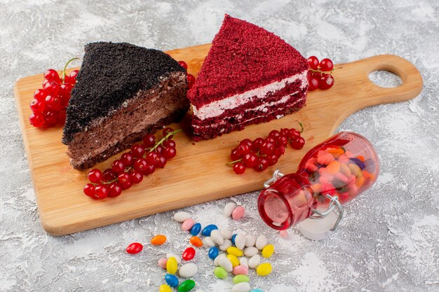 사탕과 나무 책상에 크림 초콜릿과 과일 전면 가까이보기 맛있는 케이크 조각